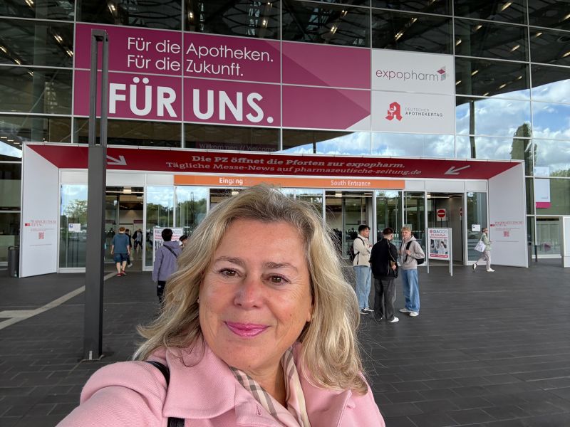 Dr. Sybille Buchwald-Werner from Newday at pharmacy conference entrance with signage